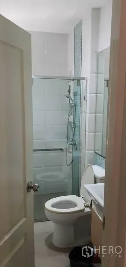 บ้าน ขายในKhan Na Yao, Bangkok - ห้องน้ำทันสมัยพร้อมกระเบื้องสีขาว ตู้อาบน้ำกระจก อ่างล้างหน้า และโถสุขภัณฑ์