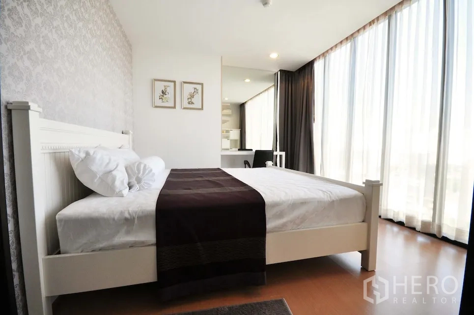 คอนโด ให้เช่าหรือขายในWatthana, Bangkok - ห้องนอนกระจกมุม เตียงสีขาว โต๊ะทำงาน ผนังลาย และวิวเมือง