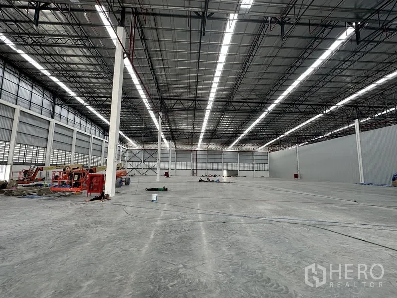 Factory for rent in Khlong Luang, Pathum Thani - Expansive column-free warehouse space with power-floated concrete floor and roof lights.