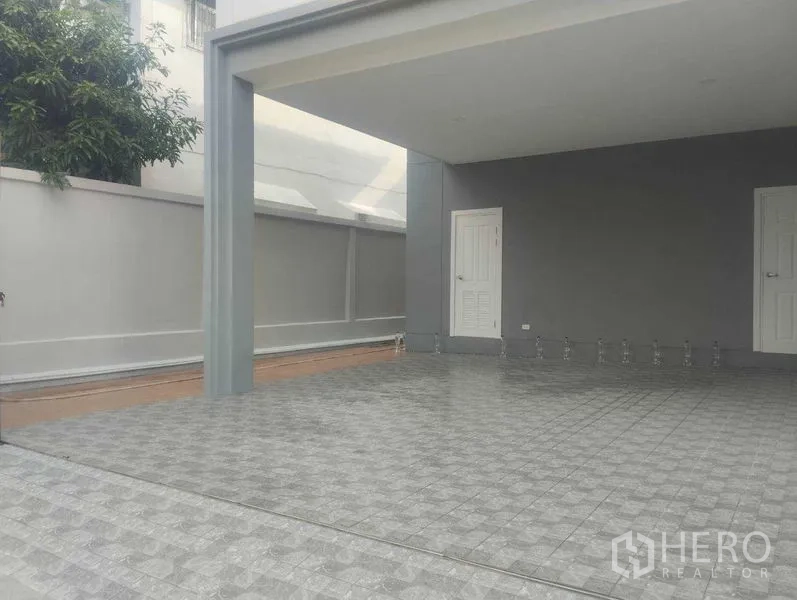 บ้าน ขายในPhra Khanong, Bangkok - โรงจอดรถมีหลังคาพื้นกระเบื้องกว้างขวาง พร้อมประตูเก็บของด้านหลัง