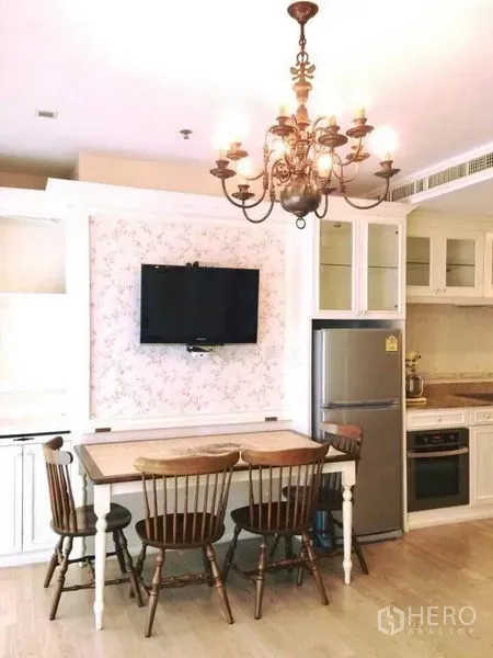 คอนโด ให้เช่าในKhlong Toei, Bangkok - มุมทานข้าวโต๊ะไม้ เก้าอี้ไม้ ทีวีติดผนัง และครัวขนาดกะทัดรัดพร้อมตู้เย็นสแตนเลสและตู้กระจก