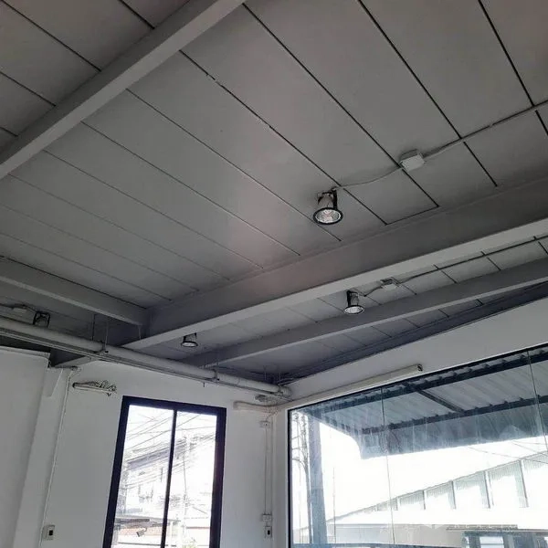 零售空间 出租在Lat Phrao, Bangkok - 灰色外露天花搭配射灯，旁为大面积玻璃立面与窗户。