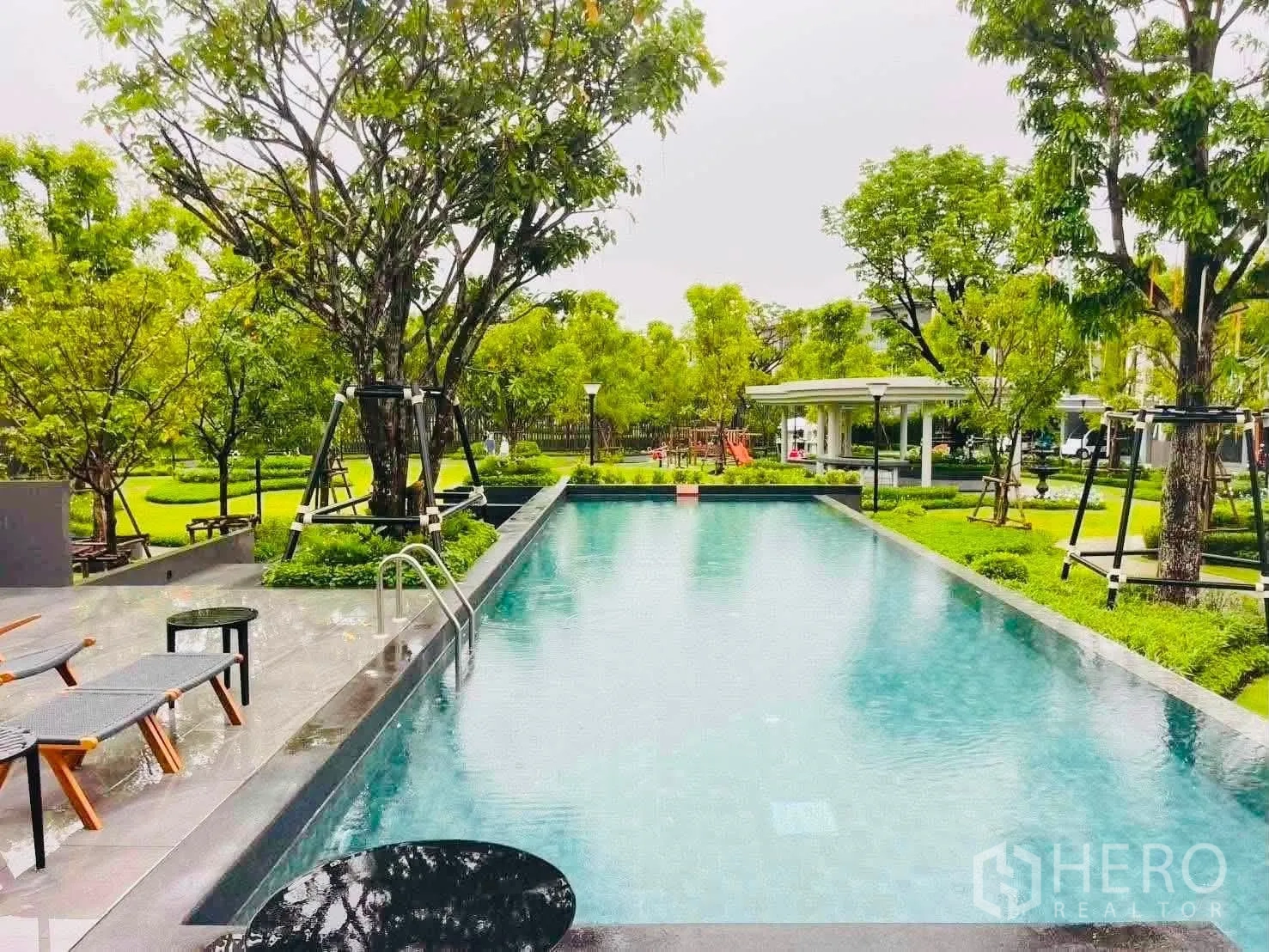 ทาวน์เฮาส์ for rent in Bang Phli, Samut Prakan - สระว่ายน้ำกลางแจ้งทรงสี่เหลี่ยม พร้อมที่นั่งริมสระ ท่ามกลางต้นไม้