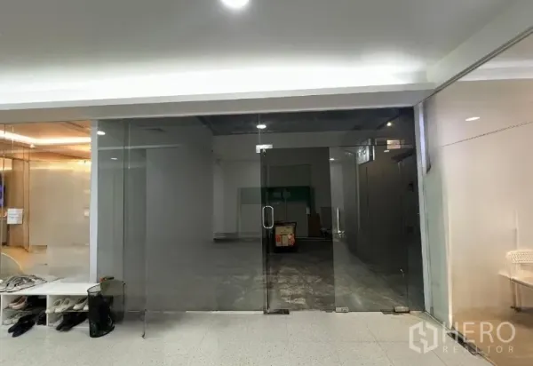 零售空间 出租 - 空置商铺，整面落地玻璃门头与双开门，对内走廊可见度高。