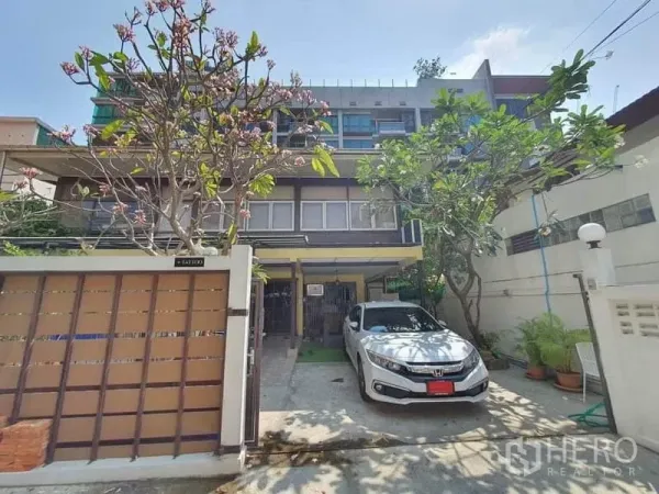 独立式住宅 出租在Watthana, Bangkok - 多层独栋别墅外观，带庭院大门、车位与成熟绿树，位于曼谷瓦他那区。