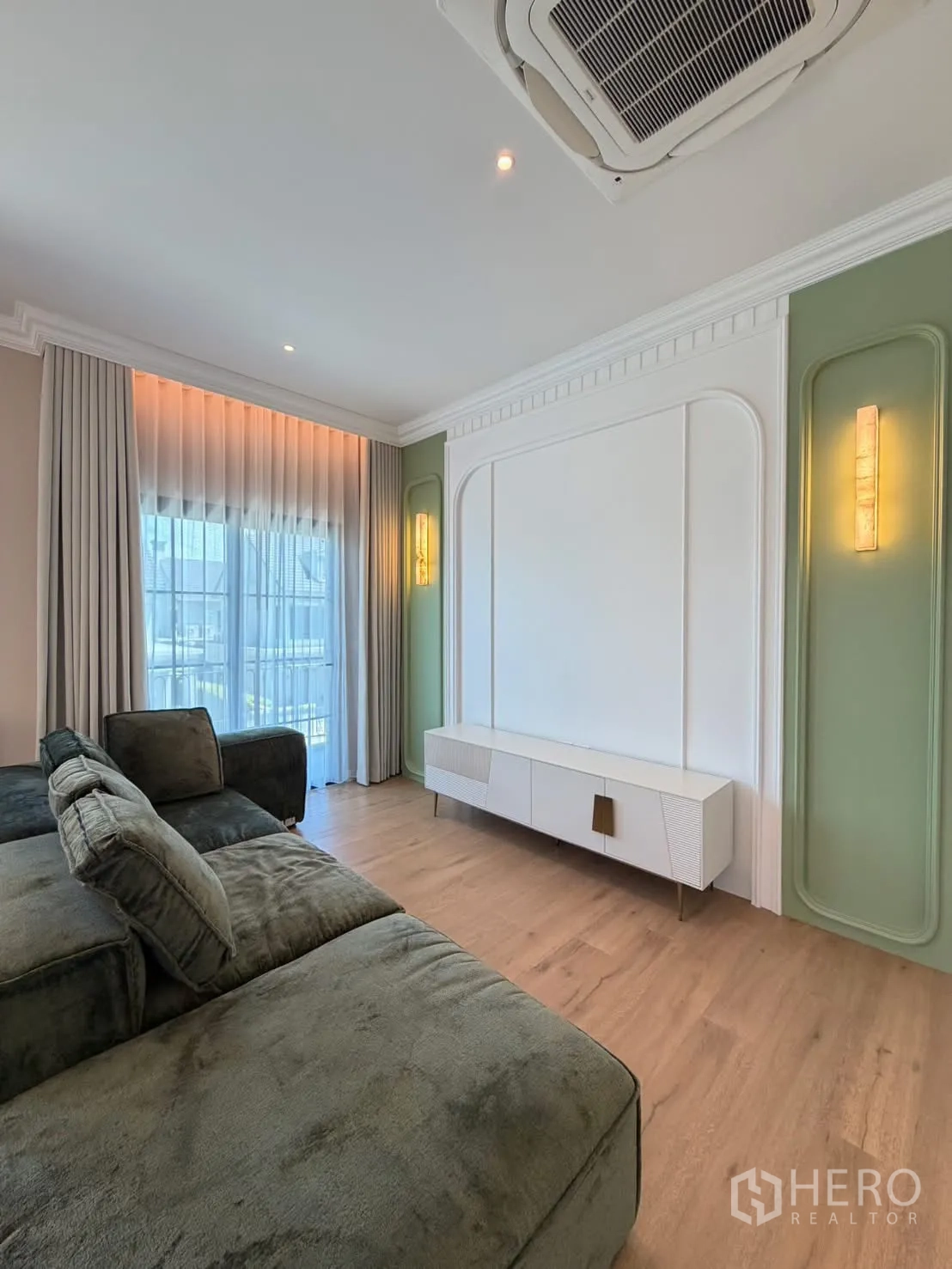 Detached House for rent in Saphan Sung, Bangkok - Family lounge with large sectional sofa facing a feature wall and TV console.