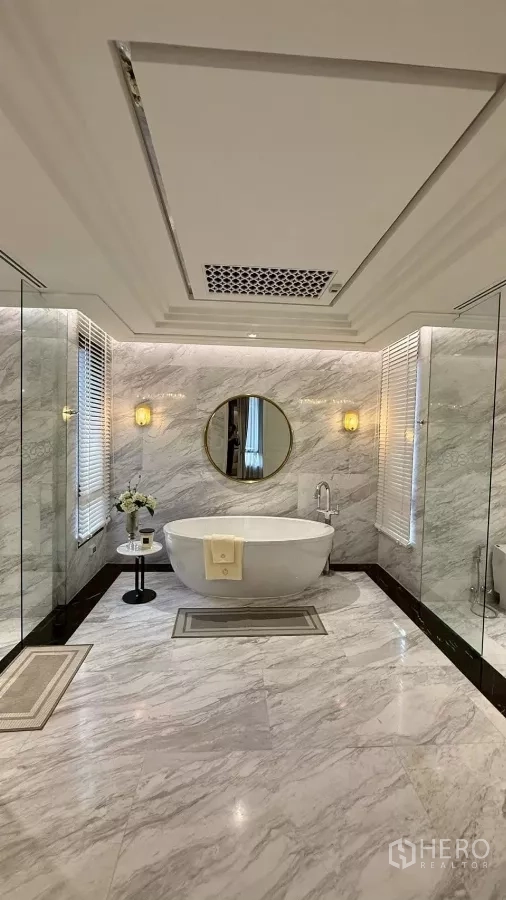 Detached House for sale in Saphan Sung, Bangkok - Luxury bathroom with freestanding bathtub, marble walls and a round mirror.