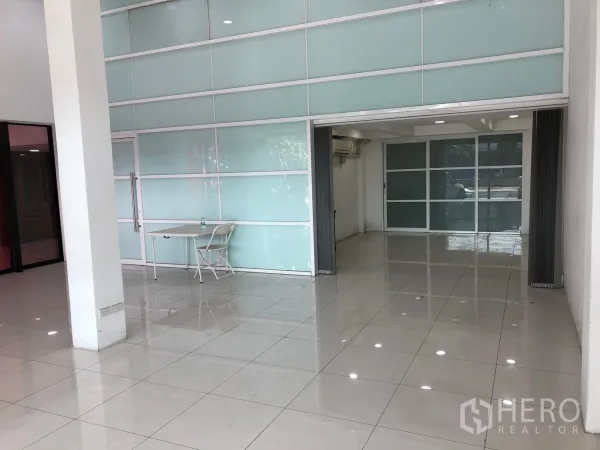 店屋 出租或出售在Khan Na Yao, Bangkok - 开阔零售区，整面磨砂玻璃墙和可折叠隔断，地面光洁如新。