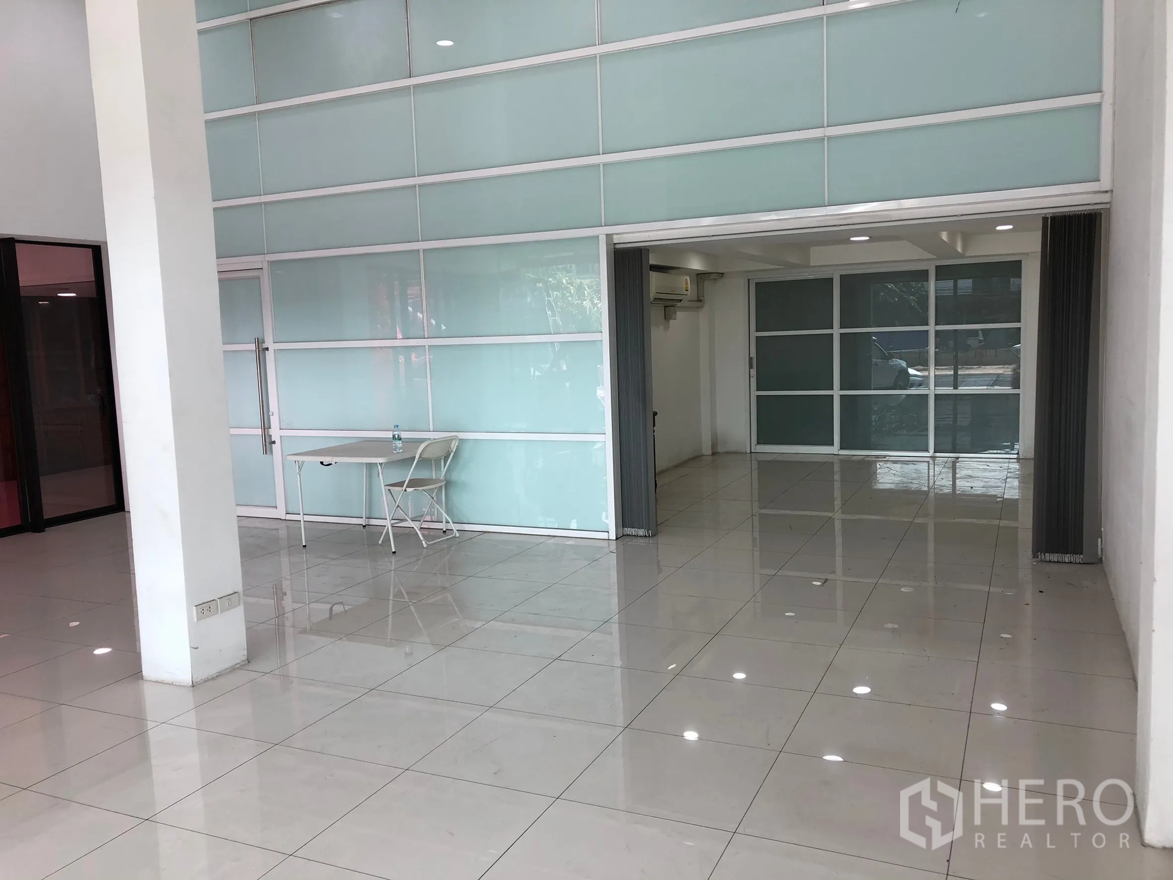 店屋 出租或出售在Khan Na Yao, Bangkok - 开阔零售区，整面磨砂玻璃墙和可折叠隔断，地面光洁如新。