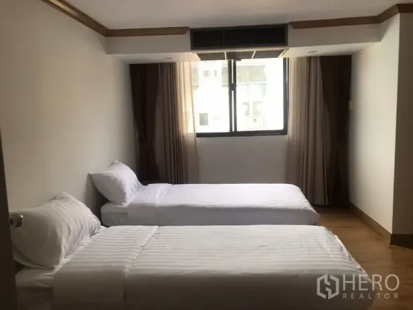 Condominium for rent in Watthana, Bangkok - Guest bedroom with two single beds, wood flooring and a curtained window.