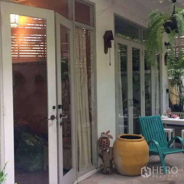 บ้าน ให้เช่าในSathon, Bangkok - เฉลียงหน้าบ้านมีประตูบานเฟรนช์ ชุดนั่งเล่น และไม้ใบเขตร้อน