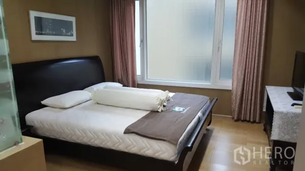 คอนโด ให้เช่าในKhlong Toei, Bangkok - ห้องนอนสว่าง หน้าต่างบานใหญ่ ผ้าม่านสีชมพู และเตียงไม้สีเข้ม