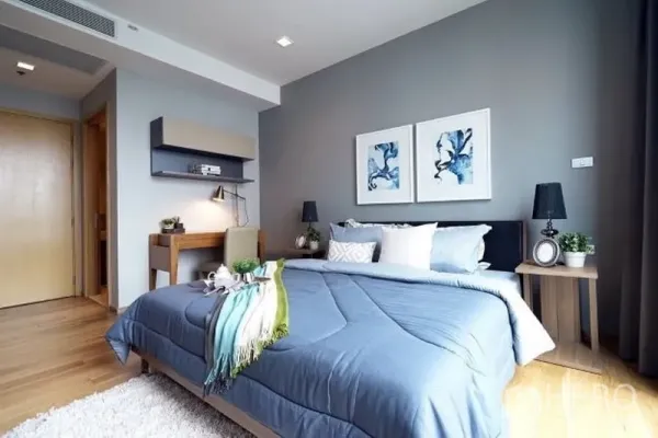 คอนโด ให้เช่าในWatthana, Bangkok - ห้องนอนอบอุ่น ชุดผ้าปูที่นอนสีน้ำเงิน โต๊ะทำงาน งานศิลป์บนผนัง และพื้นไม้