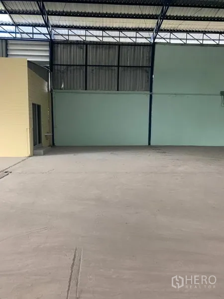 工厂 出租在Khlong Luang, Pathum Thani - 仓库内部，混凝土地坪、金属墙体与高屋架，旁侧设有功能间/卫生间