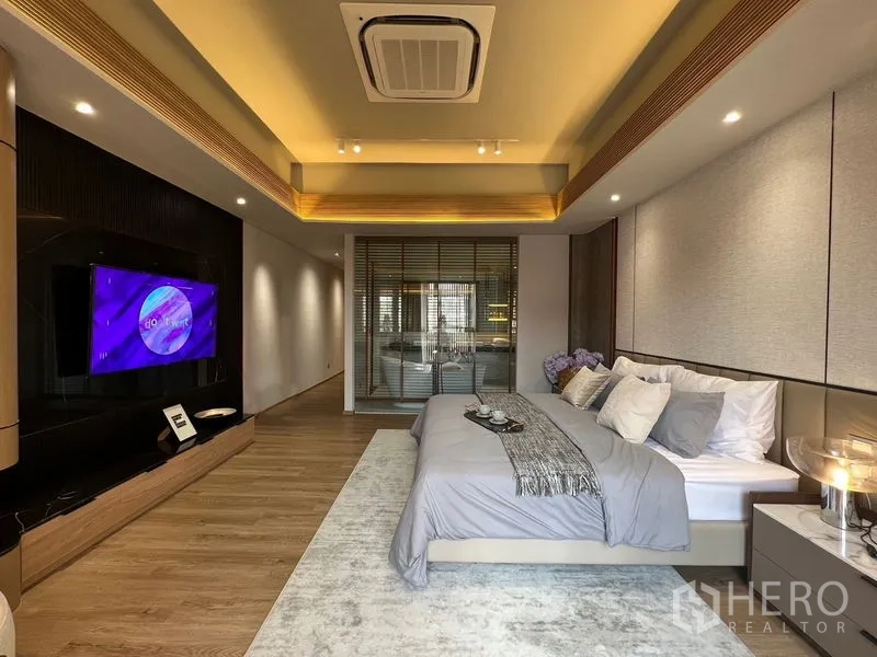 联排别墅 出售在Lat Phrao, Bangkok - 宽阔主卧套间，阶梯式天花与电视墙，后接套卫