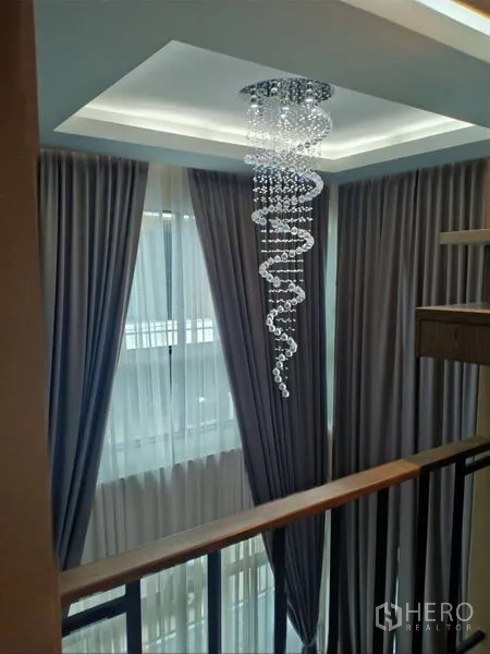 Detached House for rent in Thanyaburi, Pathum Thani - Sparkling spiral chandelier above the landing framed by tall windows and drapes.
