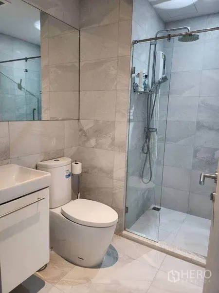 คอนโด ให้เช่าในWatthana, Bangkok - ห้องน้ำโมเดิร์นกรุกระเบื้องลายหินอ่อน ฝักบัวแบบกระจกกั้น เรนชาวเวอร์ และอ่างล้างหน้ากับโถสุขภัณฑ์
