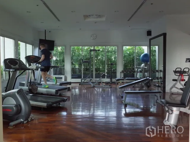 คอนโด ให้เช่าในWatthana, Bangkok - ห้องฟิตเนสของคอนโดสว่างโปร่ง มีลู่วิ่ง เครื่องเวท และพื้นไม้ มองเห็นต้นไม้