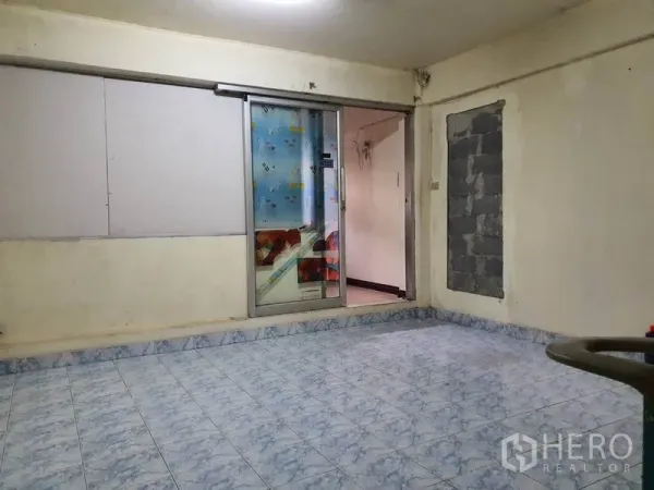 Shophouse for rent in Bang Rak, Bangkok - Upper-floor room with blue patterned tiles and a sliding glass door, suitable for office or storage.