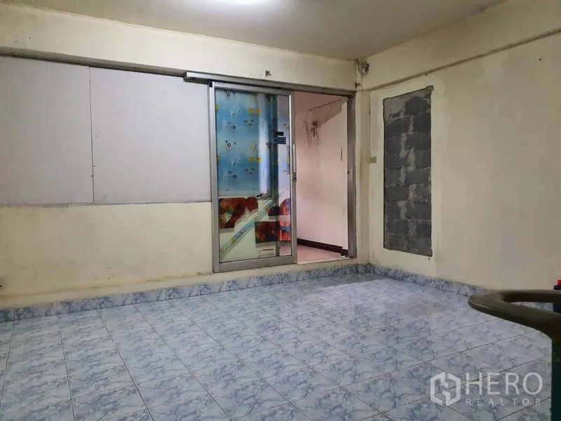 Shophouse for rent in Bang Rak, Bangkok - Upper-floor room with blue patterned tiles and a sliding glass door, suitable for office or storage.