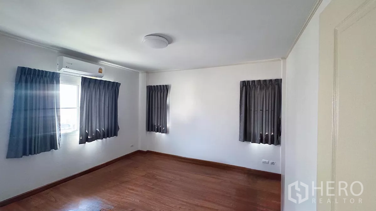 บ้าน ขายในLat Krabang, Bangkok - ห้องนอนมุมบ้าน หน้าต่างหลายบาน พื้นไม้ แอร์ และผ้าม่านสีเทา