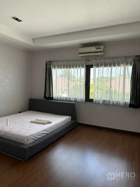 ทาวน์เฮาส์ ขายในLat Phrao, Bangkok - ห้องนอนกว้าง มีเตียงแบบเตี้ย หน้าต่างบานใหญ่และเครื่องปรับอากาศ