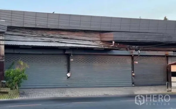 คลังสินค้า ให้เช่าในLat Phrao, Bangkok - ด้านหน้าโกดังติดถนน ประตูม้วนหลายบานและทางเท้ากว้าง