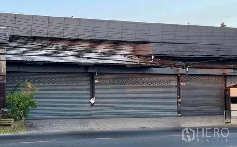 货栈 出租在Lat Phrao, Bangkok - 临街仓库外立面，多扇金属卷帘门与宽阔人行道