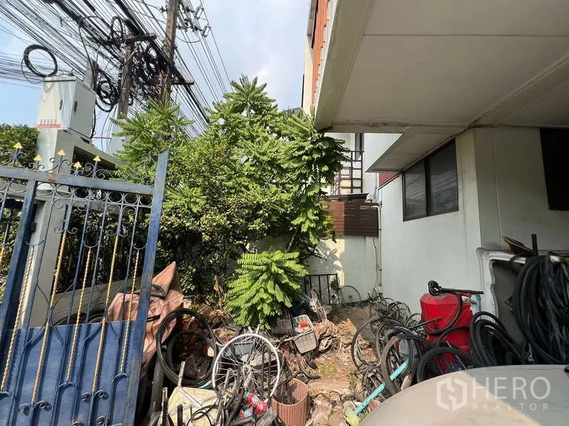独立式住宅 出售在Suan Luang, Bangkok - 房屋侧院带成熟绿植，与围栏相邻，私密性良好。