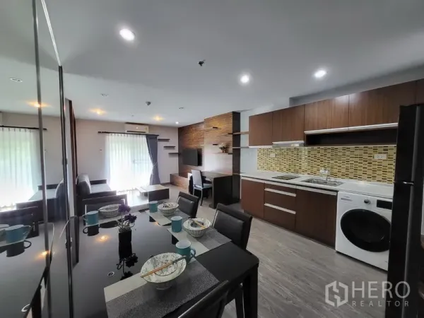 Condominium for rent in Phra Khanong, Bangkok - Open-plan dining and kitchen with wood cabinetry, mosaic backsplash, and washing machine.