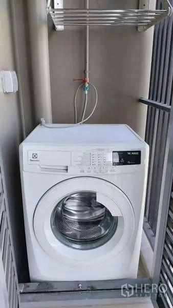 Condominium for rent in Khlong Toei, Bangkok - Balcony utility area with front-load washing machine and drying rack at The Crest Sukhumvit 34.