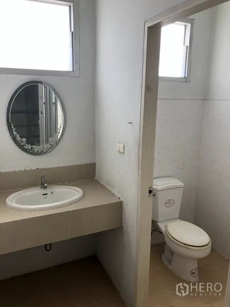 工厂 出租在Pathum Thani - 干净的卫生间，内有独立马桶间、洗手台与镜子。