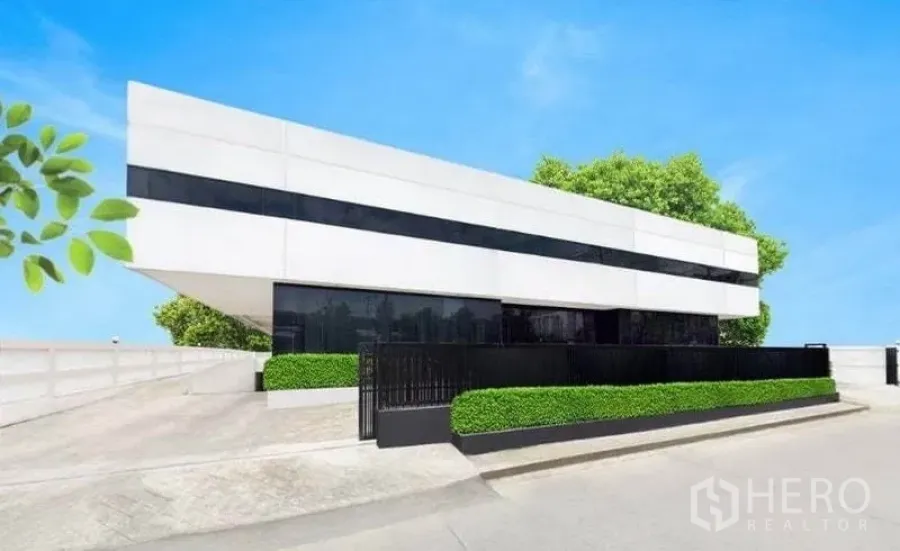 คลังสินค้า ให้เช่าในBang Phli, Samut Prakan - อาคารอุตสาหกรรมสีขาวสมัยใหม่ หน้าต่างคาดดำ ประตูรั้ว และแนวพุ่มไม้ตัดแต่ง