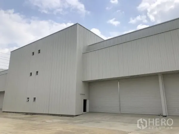 工厂 出租在Khlong Luang, Pathum Thani - 白色钢结构厂房外观，多个卷闸门与装卸前场。