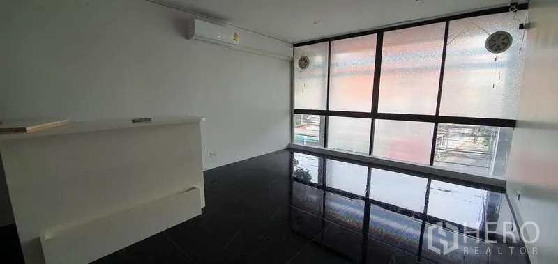 Home Office for rent in Khlong Toei, Bangkok - Upper office room with large frosted windows and dark flooring.