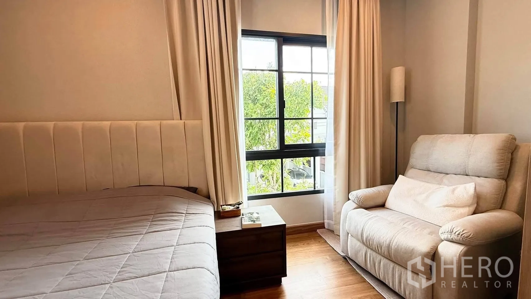 独栋房屋 for rent in Bang Phli, Samut Prakan - 卧室一角配大窗、单人沙发、床头柜与窗帘。