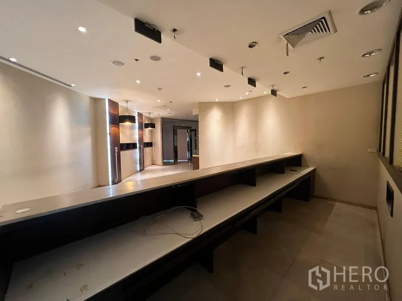 零售空间 出租 - 后勤工作区，长工作台与架子，位于服务区后方