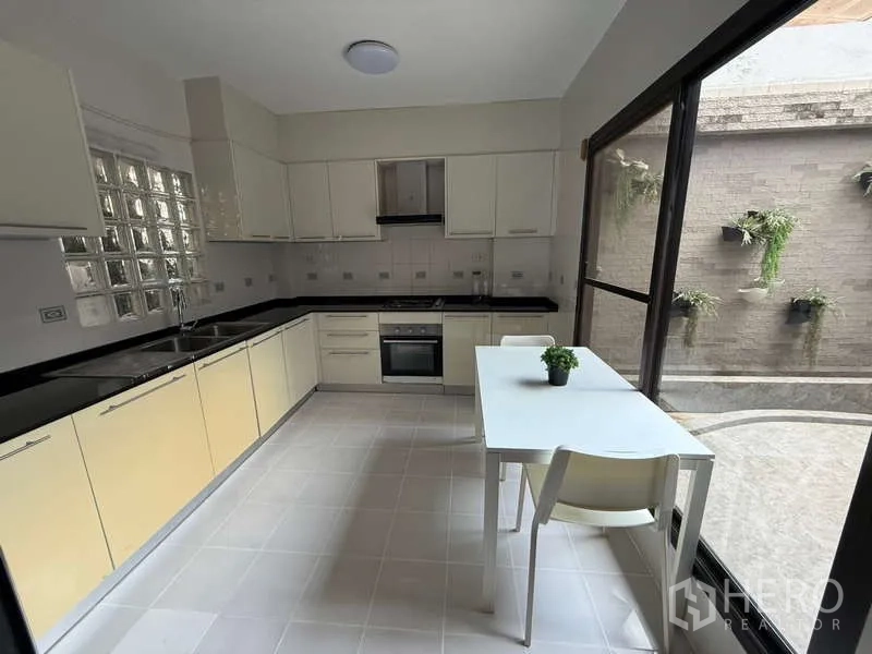 ทาวน์เฮาส์ ให้เช่าในKhlong Toei, Bangkok - ห้องครัวแยก เคาน์เตอร์และตู้เก็บของครบ มองเห็นคอร์ตยาร์ด