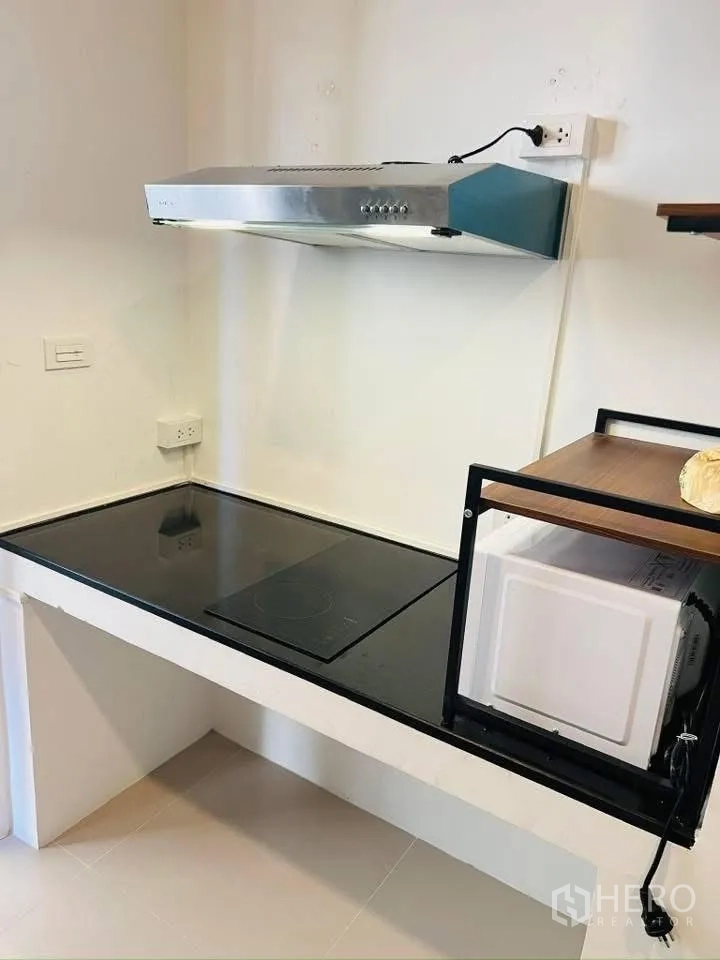 บ้านเดี่ยว for rent in Prawet, Bangkok - มุมครัวมีเตาไฟฟ้า เครื่องดูดควันสเตนเลส และชั้นสำหรับไมโครเวฟ.