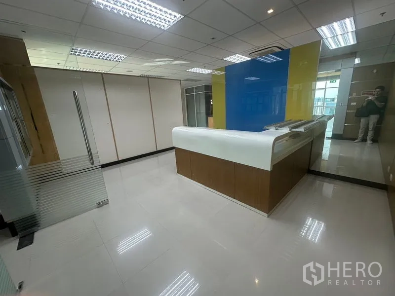 办公空间 出租在Suan Luang, Bangkok - 现代接待区，弧形前台、玻璃门与亮面地砖。