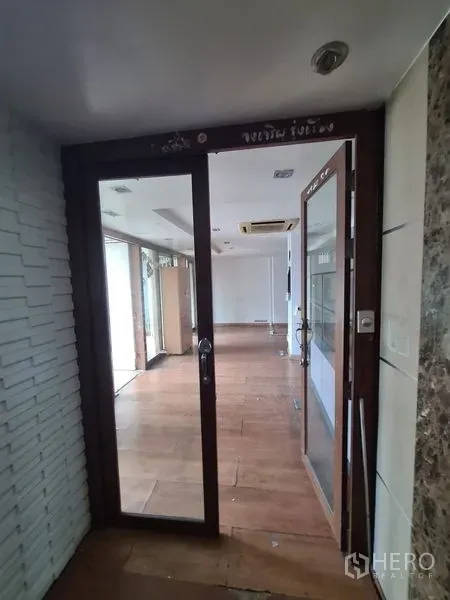 办公空间 出租在Bang Rak, Bangkok - 玻璃门入口的办公室，木地板与吊顶嵌入式空调。