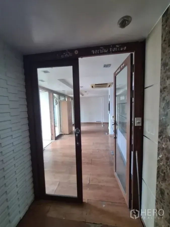 办公空间 出租在Bang Rak, Bangkok - 玻璃门入口的办公室，木地板与吊顶嵌入式空调。