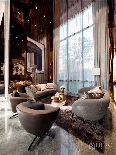 Condominium for rent in Sathon, Bangkok - Cozy lobby lounge with high drapes, sofas and floor-to-ceiling windows.