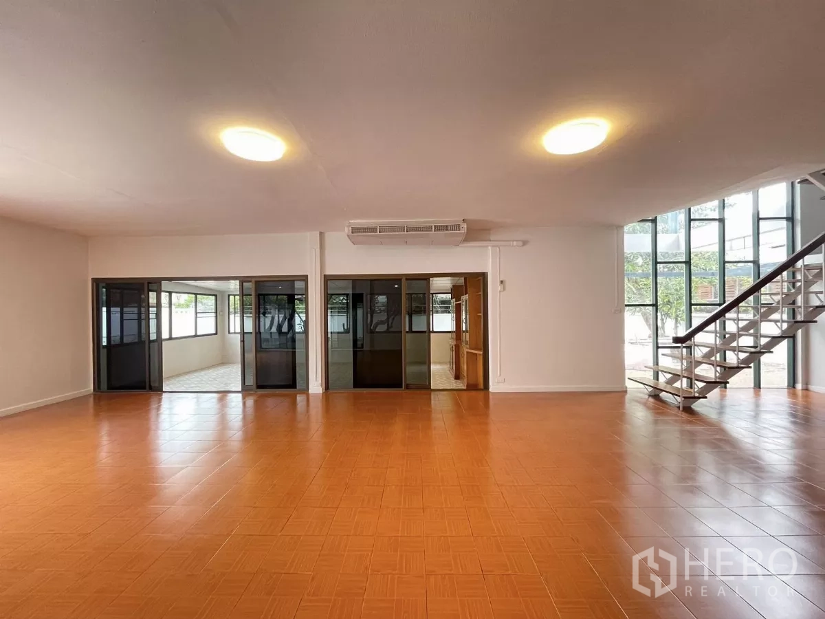带办公室的家 出租在Din Daeng, Bangkok - 宽敞空间面向落地玻璃与钢制楼梯，多组推拉门分隔。