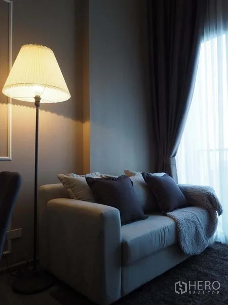 คอนโด ให้เช่าในKhlong San, Bangkok - มุมนั่งเล่นพร้อมโซฟา โคมไฟตั้งพื้น และผ้าม่านหน้าต่างสูงจรดเพดาน