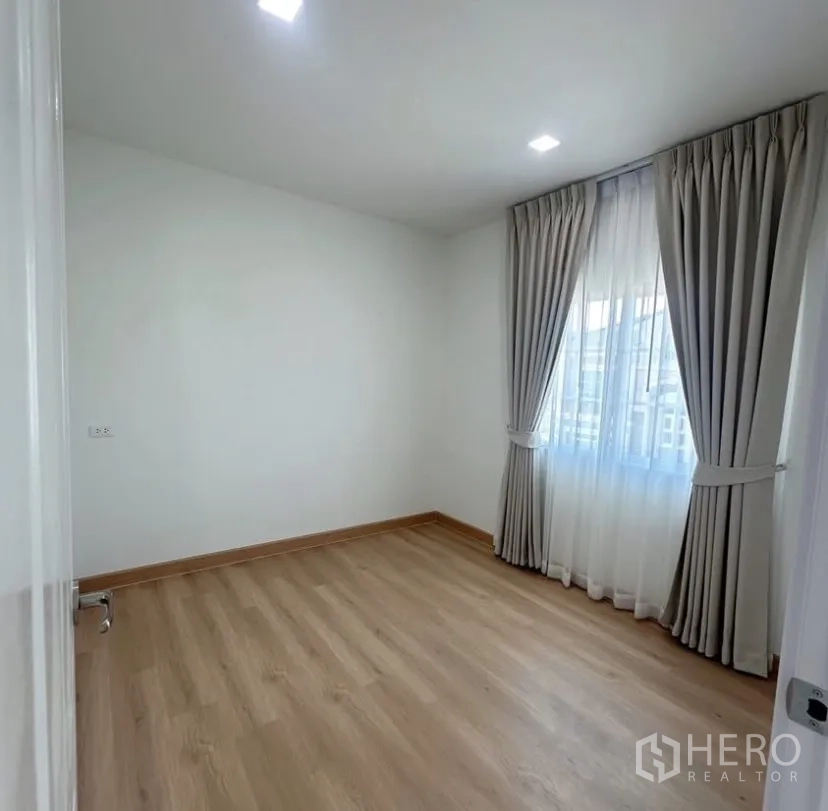 บ้าน ให้เช่าในMueang Samut Prakan, Samut Prakan - ห้องนอนสว่าง พื้นไม้โทนอ่อน ผนังสีขาว และหน้าต่างติดผ้าม่าน