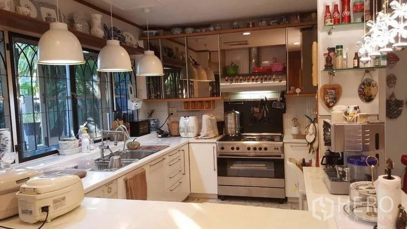 Detached House for rent in Bang Kapi, Bangkok - U-shaped kitchen with large stove, pendant lights and wide counters.