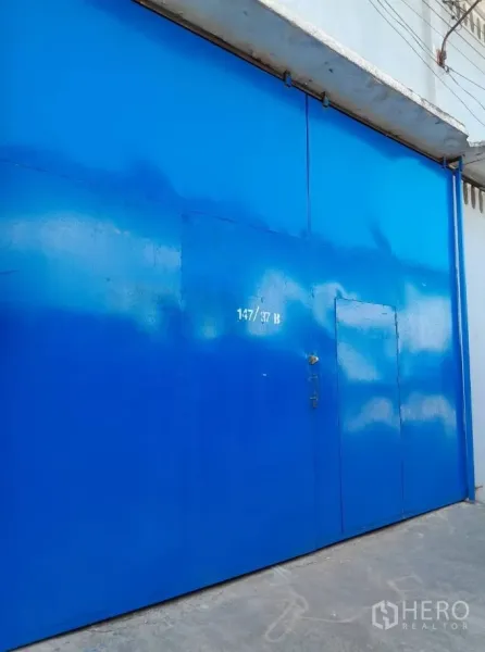 คลังสินค้า ให้เช่าในBang Phli, Samut Prakan - ภาพระยะใกล้ของประตูโกดังเหล็กสีน้ำเงินบานใหญ่ด้านหน้า