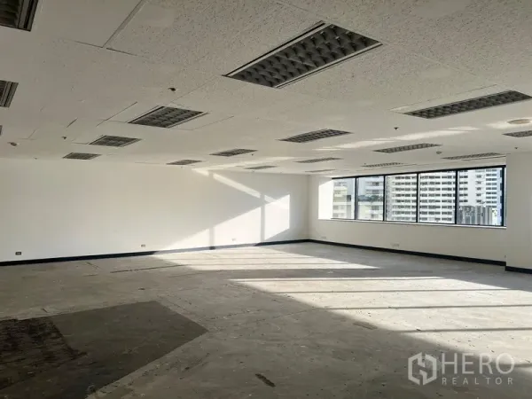 Office Space for rent in Khlong Toei, Bangkok - Empty office unit with large glazing, fluorescent lighting, and concrete subfloor ready for fit‑out near BTS Nana.