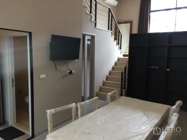 ทาวน์เฮาส์ ให้เช่าในSuan Luang, Bangkok - โซนรับแขกและทานอาหารแบบโอเพ่นแปลน มีบันได ชั้นวาง และห้องน้ำสำหรับแขก